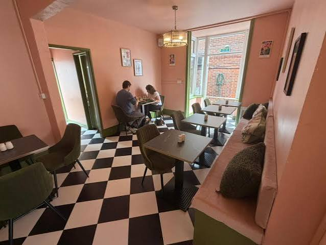 Wide view of the checkerboard dining room and green banquette seating